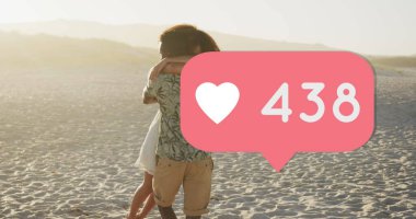 Heart icon with increasing numbers against african american couple hugging each other on the beach. social media networking and vacation concept