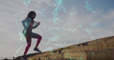 Denizin kenarında koşu yapan kadının üzerinde birden fazla şekil var. Dijital arayüz küresel spor ve performans konsepti dijital olarak oluşturulmuş görüntü.