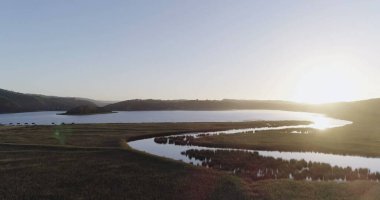 Güneş doğarken çimen dağlarının ve göl manzarasının güzel manzarası. Doğa ve ekoloji kavramı.
