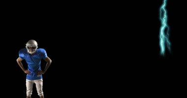 Mavi formalı futbolcu arka planda yıldırımla güvenle ayakta duruyor. Sporcu, spor, güç, enerji, elektrik, güven
