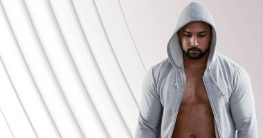 Gri kapüşonlu atletik adam soyut arka plandaki fitness hedeflerine odaklanıyor. Spor, atlet, spor, egzersiz, motivasyon, kararlılık