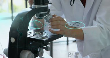 Laboratuvarda mikroskop kullanan bilim adamı, matematiksel denklemlerle araştırmaya odaklanıyor. Laboratuvar, bilim, biyoteknoloji, analiz, deney