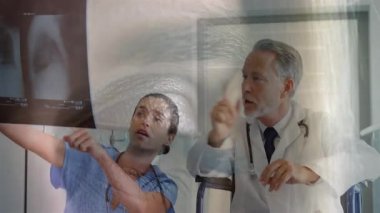 Röntgenler dijital veri örtüsüyle analiz ediliyor, hastane ortamında tıbbi uzmanlar var. Sağlık, tanı, radyoloji, teknoloji, analiz, uzmanlık