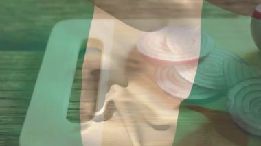 Kesme tahtasının üzerinde dilimlenmiş kırmızı soğanlarla Nijerya bayrağı animasyonu var. Ulusal, yemek, kültür, aşçılık, amblem, sebze