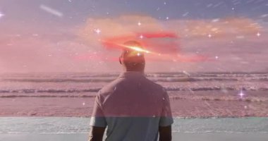 Gökyüzünde renkli kozmik animasyonlarla sahilde duran adam. fantezi, gerçeküstü, dijital, doğa, sükunet