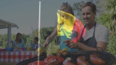 Ailesiyle açık havada barbekü, arka planda Belçika bayrağı animasyonu. piknik, ızgara, kutlama, yaz, bayraklar, aşçılık
