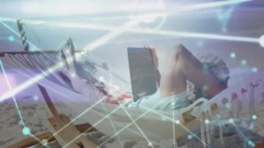 Sahilde hamakta dinlenen ve dijital ağ animasyonu yapan kişi. Rahatlama, tatil, rahatlık, sükunet, teknoloji, bağlantı