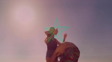 Sahilde yürürken, yeşil yıldız animasyonu yapan çift el ele tutuşuyor. Aşk, tatil, deniz kenarı, dijital, gezinti, sahil