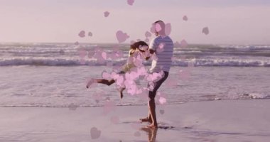 Baba ve kızı plajda pembe kalp animasyonlarıyla oynuyorlar. Aile, bağ, eğlence, neşe, aşk, mutluluk