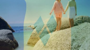 El ele tutuşmuş, iki çocuk okyanus kıyısında kayalıklarda animasyon örtüsüyle. Arkadaşlık, macera, keşif, çocukluk, hayal gücü, doğa