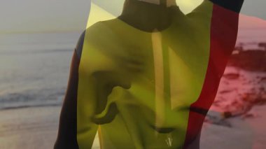 Okyanusun kenarında duran, gün batımında şeffaf bayrak tutan kişi. Siluet, bayrak sallama, özgürlük, deniz manzarası, ilham verici, huzur