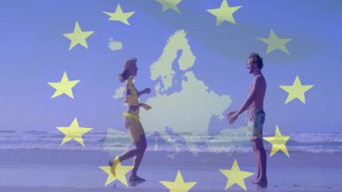 Sahilde dans eden, Avrupa Birliği bayrağı taşıyan bir çift. Tatil, seyahat, romantizm, kutlama, özgürlük, yaz