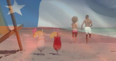 Okyanusa koşan, bayrak animasyonu altında sahilde kokteyl içen bir çift. Tatil, cennet, rahatlama, tropikal