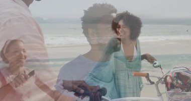 Sahilde bisiklet sürerken, arkada okyanus dalgaları olan gülümseyen bir çift. Bisiklet, eğlence, mutluluk, açık hava, tatil, yaşam tarzı