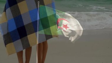 Okyanus tarafından örtülmüş Cezayir bayrağı animasyonu olan bir çift. İlişki, vatanseverlik, seyahat, açık hava, kıyı şeridi, sıcaklık