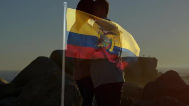 Kayalık sahilde kucaklaşan Ekvador bayrağı sallayan çift. Aşk, vatanseverlik, açık hava, kıyı şeridi, seyahat, doğa.