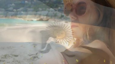 Plajda, güneş gözlüğü takan Arjantin bayrağı animasyonu ile kaplanmış bir kadın. Tatil, dinlenme, yaz, deniz kenarı, moda, güneşli