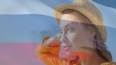 Sarı elbiseli ve şapkalı, Rus bayrağına karşı duran bir kadın. Moda, vatanseverlik, kıyafet, ulusal, renk, kimlik