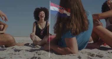 Kumsalda dinlenen Hırvat bayraklı arkadaşlar kuma dikilip animasyonun tadını çıkarıyorlar. Tatil, seyahat, arkadaşlık, sahil şeridi, boş zaman, dalgalı bayrak