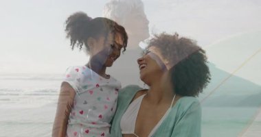 Anne ve kızı sahilde okyanus dalgalarıyla oynayıp neşeli bir animasyon yaratıyorlar. Aile, bağ, eğlence, mutluluk, şakacı, kaygısız