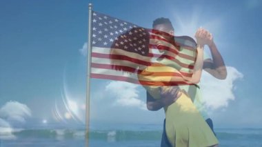 Sahilde kucaklaşan, Amerikan bayrağı parlayan güneş ışığıyla örtülü çift. Vatanseverlik, romantizm, yaz, tatil, özgürlük, birlik