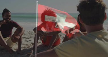 Sahilde dinlenen, ön planda İsviçre bayrağı taşıyan insanlar. Tatil, dinlenme, tatil, tatil, seyahat, yaz