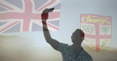 Selfie çekiyoruz, İngiliz bayrağı ve Fiji armalı silah animasyonu. Vatanseverlik, seyahat, turizm, kültür, kimlik, kutlama