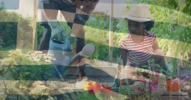 Çiçekleri canlı bahçede yetişkinle sulayan çocuk, temel bahçıvanlık dersleri alıyor. Bahçecilik, aile, doğa, ekme, bağlanma, öğretim