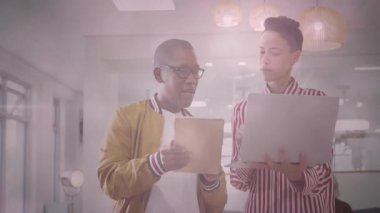 Dijital cihazlar üzerinde işbirliği yapan, modern ofiste animasyon kullanan iki kişi. Teknoloji, takım çalışması, işbirliği, yenilik, yaratıcılık, çalışma alanı