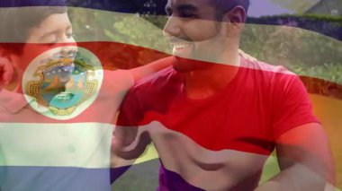 Parkta yan yana oturan Kosta Rika bayrağını taşıyan iki kişi. Dostluk, birlik, vatanseverlik, açık hava, çeşitlilik, kutlama