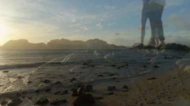 Kayalık sahilde durmuş okyanus dalgalarını ve arka planda gün batımını seyreden biri. Siluet, tefekkür, sükunet, doğa, ufuk.