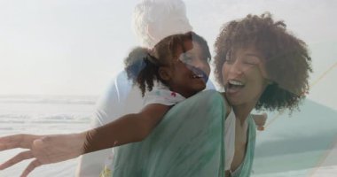 Sahildeki aile, okyanus arkaplanıyla birlikte oynayarak neşeli bir animasyon yaratıyor. Tatil, dinlenme, deniz kenarı, aile zamanı, kaynaşma, boş zaman