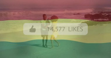 Sahilde oynarken, arka planda renkli örtülerle animasyondan hoşlanan insanlar. Tatil, yaz, eğlence, rahatlama, coşku