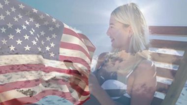 Elinde Amerikan bayrağı, kumsalda gülümseyen bir kadın gökyüzü animasyonuyla. Vatanseverlik, kutlama, yaz tatili, özgürlük, açık hava, neşe