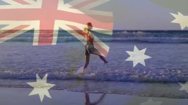 Sahilde yürüyen, Avustralya bayrağı animasyonu olan biri. Okyanus, kum, vatanseverlik, seyahat, sahil, tatil