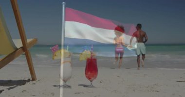 Sahilde iki kokteyl ve okyanusa doğru yürüyen çift bayrak animasyonu. Seyahat, tatil, tropikal, boş zaman, gün batımı, dinlenme
