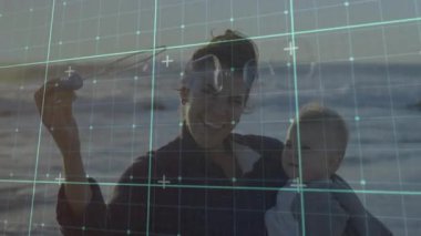 Anne kumsalda bebeği dijital ızgarayla kucaklıyor. Ebeveynlik, teknoloji, aile, bağlanma, yaz, yenilik