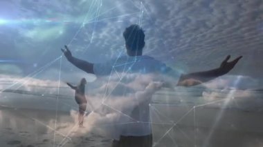 Kumsalda kolları açık bir adam, gökyüzünde ağ bağlantıları var. Teknoloji, yenilik, dijital, sanal, özgürlük, açık hava