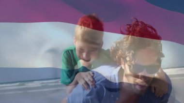 Baba, bayrak sallama animasyonunda çocuğu sırtında taşıyor. Aile, eğlence, bağlılık, eğlence, vatanseverlik, kutlama