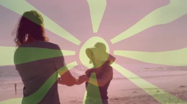 Sahilde el ele tutuşan, günbatımının tadını çıkaran, günbatımını seyreden insanlar. Okyanus, çift, romantizm, güneş ışığı, rahatlama, sükunet