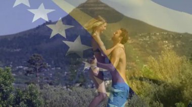 Açık havada kucaklaşan, arka planda Amerikan bayrağı sallayan mayo giymiş çift. Vatanseverlik, yaz, tatil, özgürlük, gün batımı, kutlama