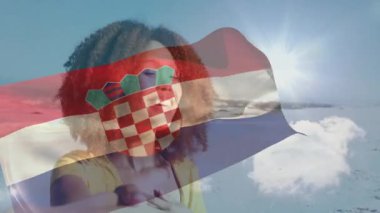 Hırvat bayrağı kışın karlı dağ manzarasına hayran olan kişinin üzerinde dalgalanıyor. Vatanseverlik, keşif, manzara, seyahat, doğa, açık hava