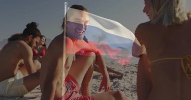 Sahilde, genç insanlar Rus bayrağının animasyonuyla dinleniyorlardı. Tatil, turizm, rahatlama, seyahat, açık hava.