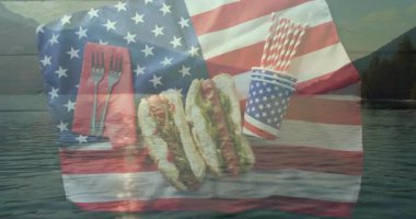 Sosisli sandviç, çatal bıçak ve pipetli Amerikan bayrağı göl kenarında animasyon yaratıyor. Vatanseverlik, barbekü, yaz, piknik, kutlama