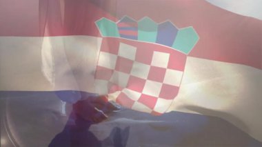 Hırvat bayrağını güneş ışığıyla sallamak gökyüzüne karşı şeffaf etki yaratıyor. Vatanseverlik, ulusal gurur, kutlama, açık hava, özgürlük, sembolik