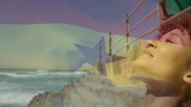 Okyanus kenarında güneşlenen kadın, arka planda Gana bayrağı animasyonu. Tropik, tatil, dinlenme, tatil, sahil, eğlence