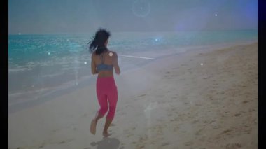 Sahilde koşan, arka planda dijital animasyon ve okyanus olan bir kadın. Spor, sağlık, teknoloji, yenilik, egzersiz, deniz kenarı