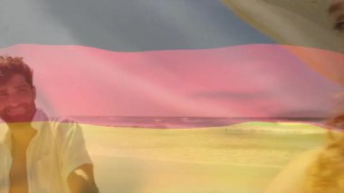 Sahilde, Alman bayrağı taşıyan bir adam güneş ışığı animasyonunda gülümsüyordu. Tatil, tatil, yaz, güneş, vatanseverlik, boş zaman