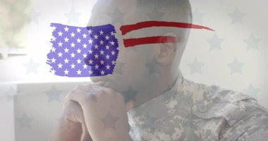 Üzerinde Amerikan bayrağı olan kamuflaj üniformalı asker derin düşünüyor. Ordu, vatanseverlik, silahlı kuvvetler, ordu, hizmet, onur