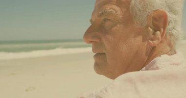 Okyanusa dikkatlice bakan, kumsalda beyaz saçlı yaşlı bir adam. Düşünce, sahil, sahil, huzur, huzur, yansıtma